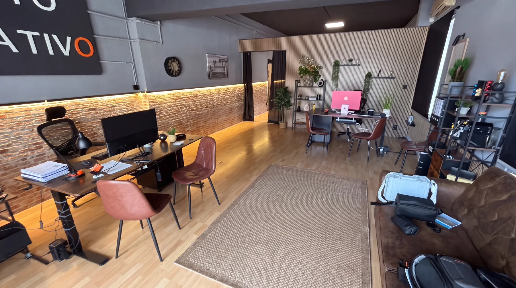 Oficina de Distrito Creativo en Sant Joan d’Alacant: pared de ladrillo, puestos de trabajo con monitores y mesa de reuniones